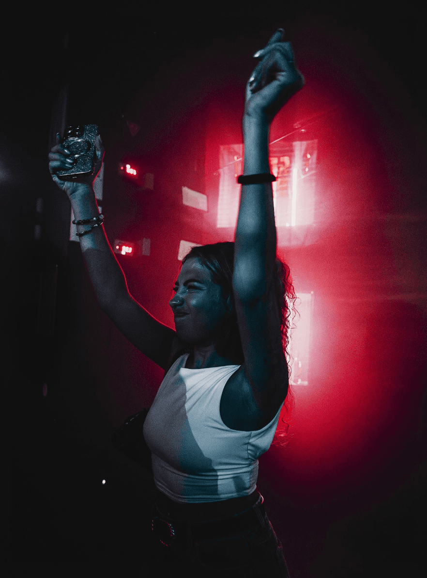 Danseuse dans le Hiboo Club sous des lumières rouges et néon.