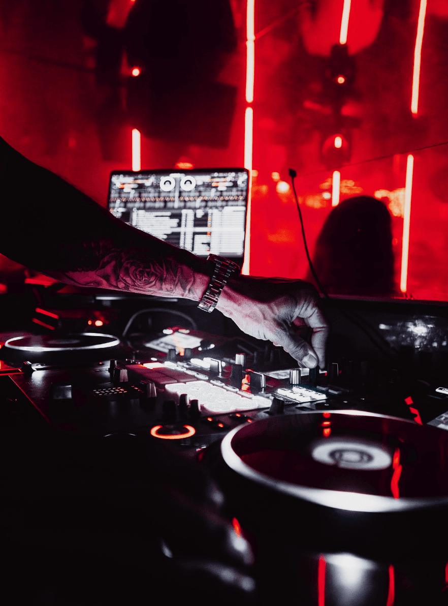 DJ en pleine performance au Hiboo Club avec la foule devant lui.
